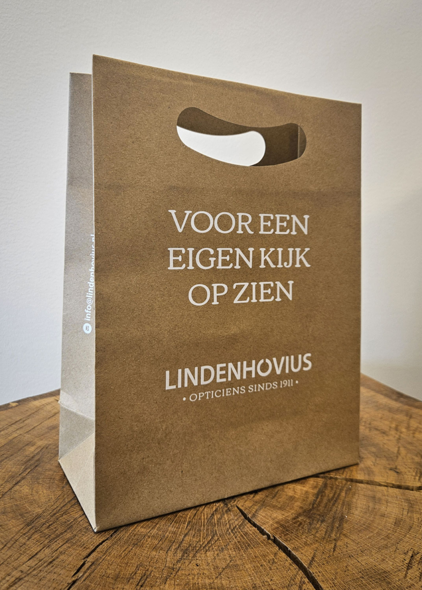 Kraft tas met witte UV-bedrukking Lindenhovius Opticiens Kraft tas van Lindenhovius Opticiens met pay-off en logo in witte UV-bedrukking